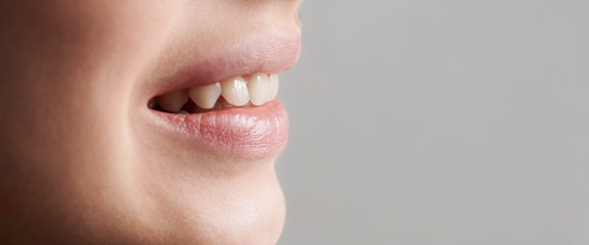 Cropped, closeup snapshot of a beautiful woman's smile, demonstrating healthy teeth. Side view. Copy space image. Oral hygiene concept
