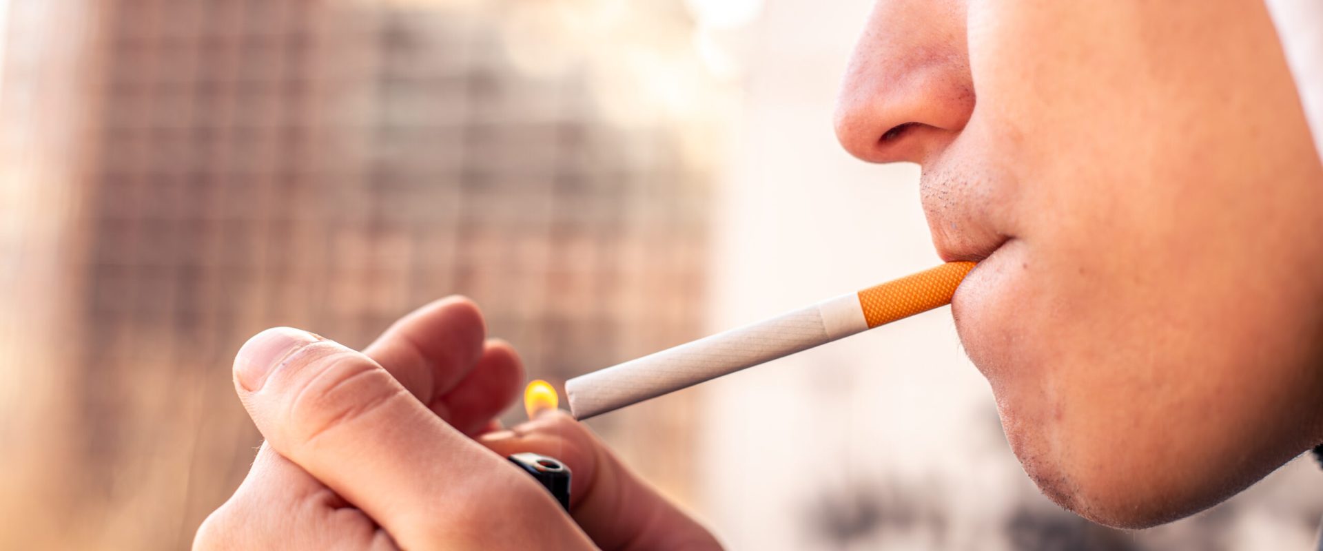 Smoking concept. Man lighting a cigarette with a lighter. High quality photo. Copy space. Smoking a cigarette close-up. Unhealthy lifestyle.